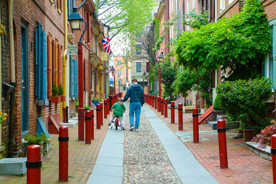 kids biking along with father in the Alley