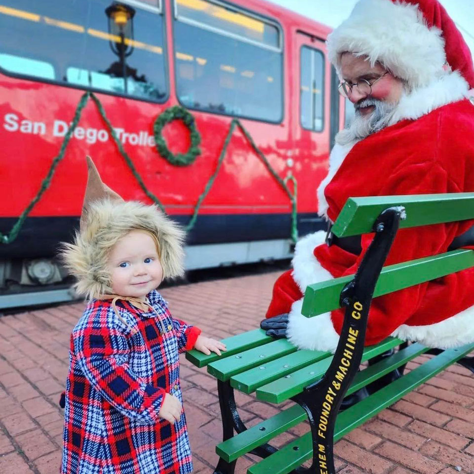 little kids standing next to Santa