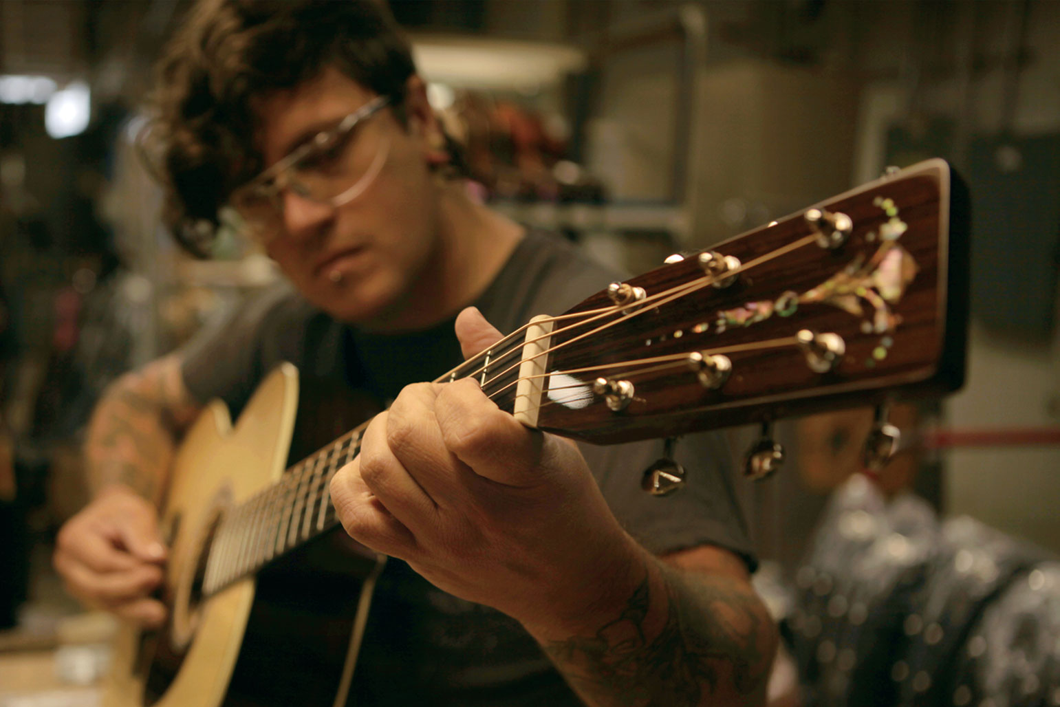 a person with glasses playing guitar