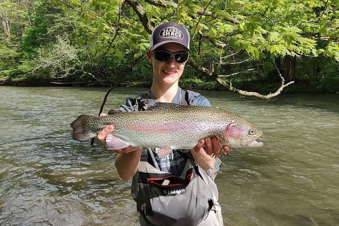 a person holding a trout caught