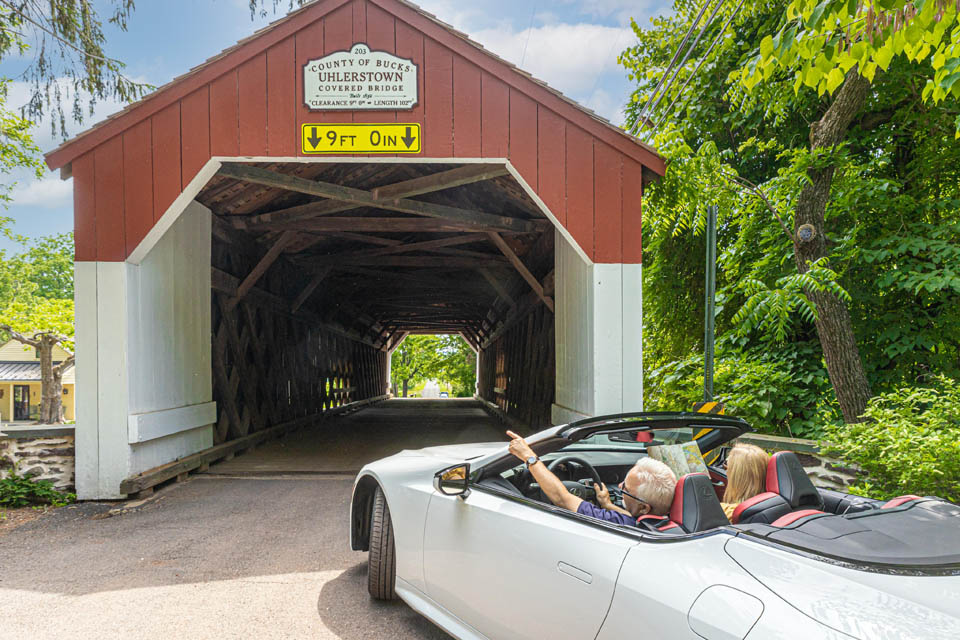 a car driving thru covered bridge