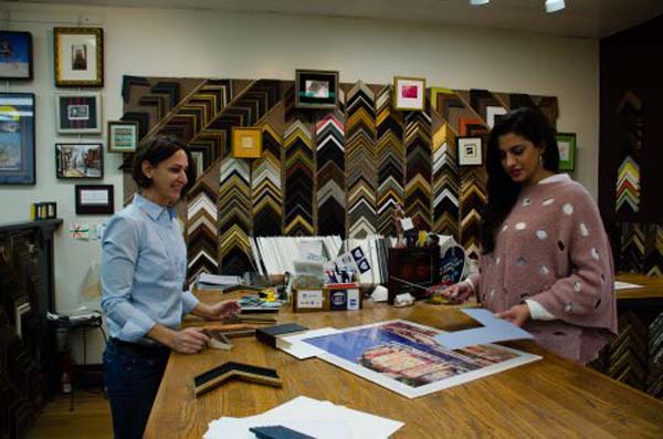 two women looking at Picture Frame at Art Gallery