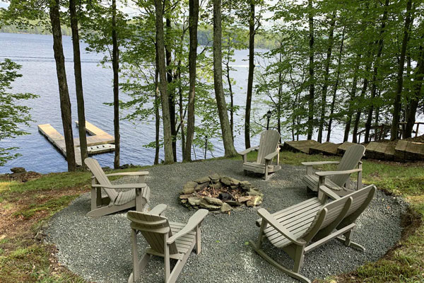 Chairs by campfire near lake