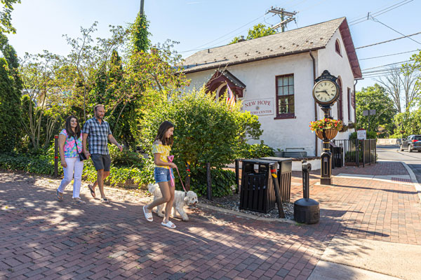 family walking on street along with dog