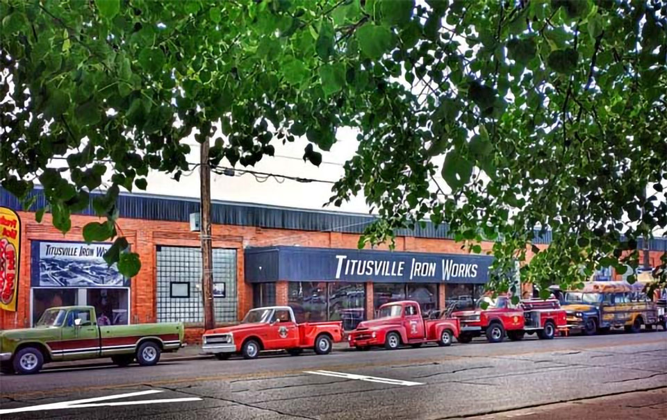 vintage cars parked infront of Iron works shop