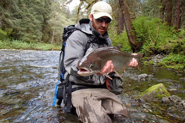 guy holding a fish catch in river