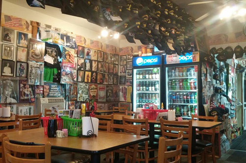 Wall filled with photo frames and hats inside hunts