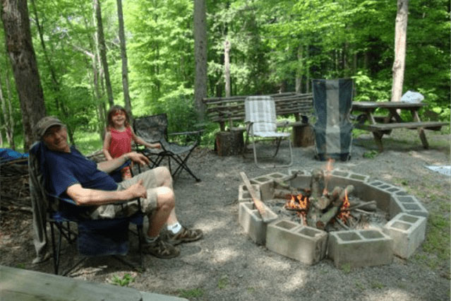 family sitting in chairs near fire pit