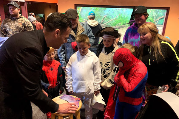 kids surrounding a magician