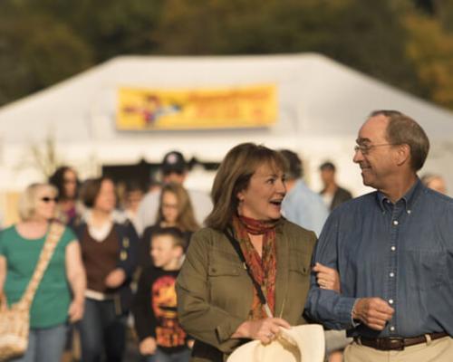 couple walking hand and hand through festival