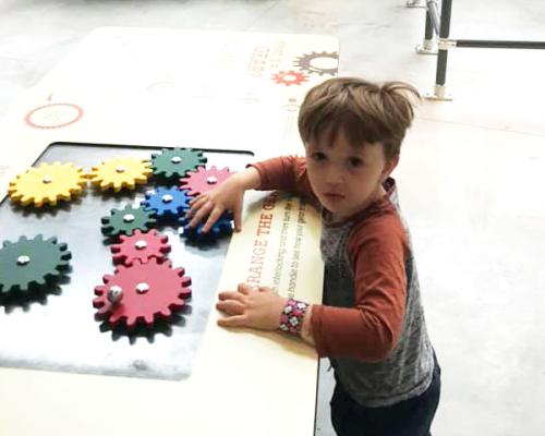 kid playing with gears at museum