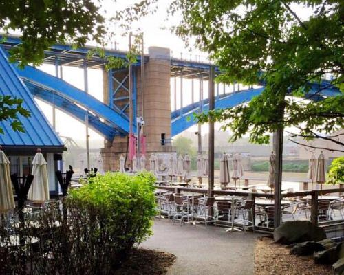 outdoor seating by river bridge in the back