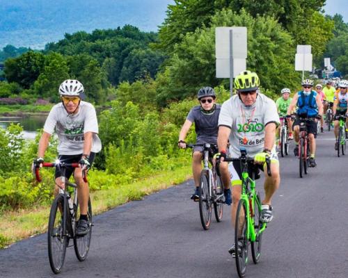 A group of people riding bikes on a Trail by a river