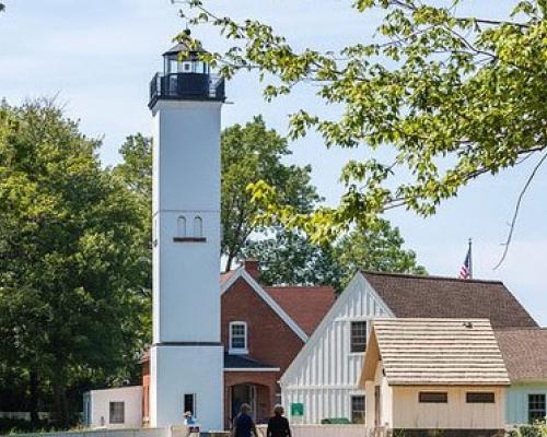 people walking by lighthouse