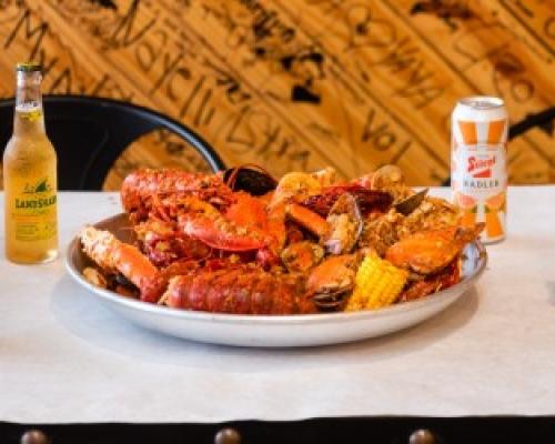 crab served in bowl next to some beer