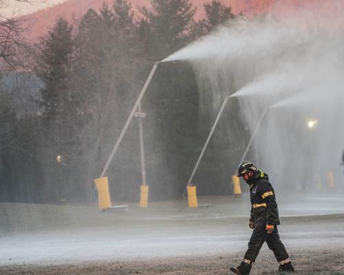 a person walking by snow making machines