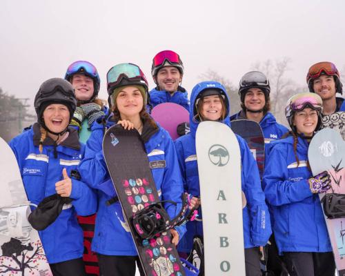 group of people posing for photo with ski gear on