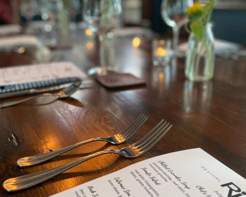 dining forks placed on table next to menu