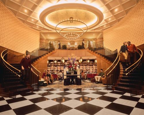  An opulent double staircase in a luxurious interior with people casually interacting.