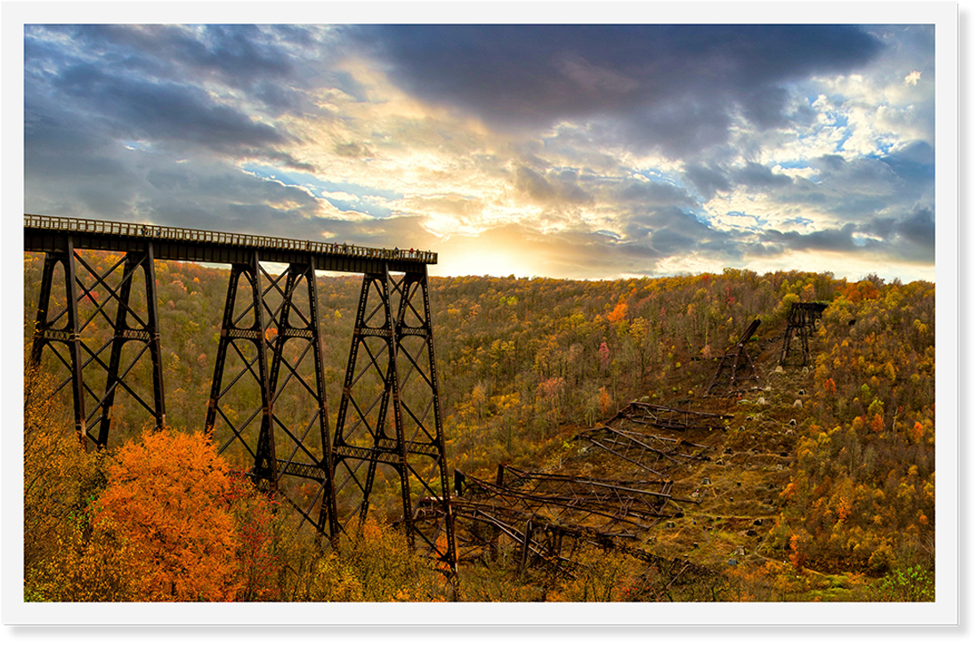 An old railroad bridge half fallen in a valley.